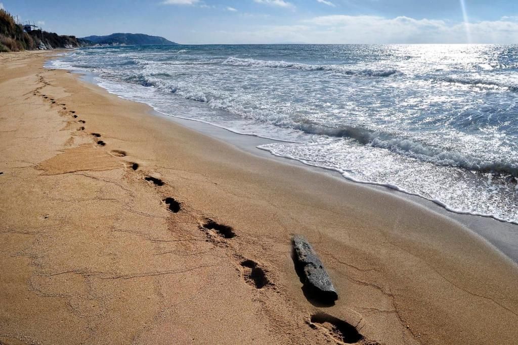 Footprints along the shoreline of Agios Georgios Beach