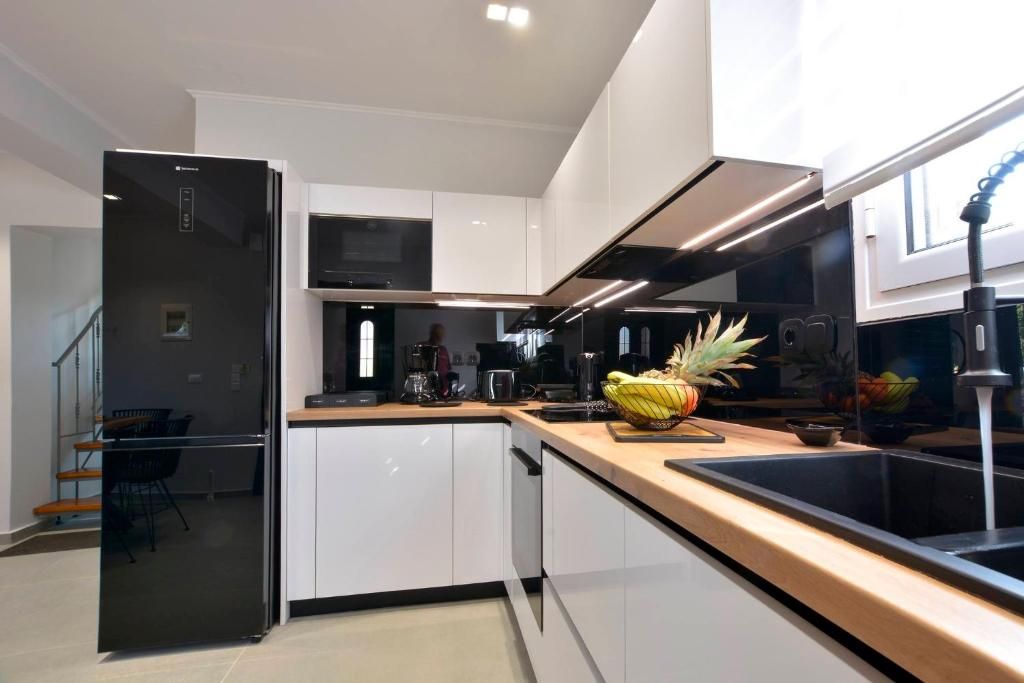 Modern kitchen with refrigerator, oven, cooktop and wooden worktop